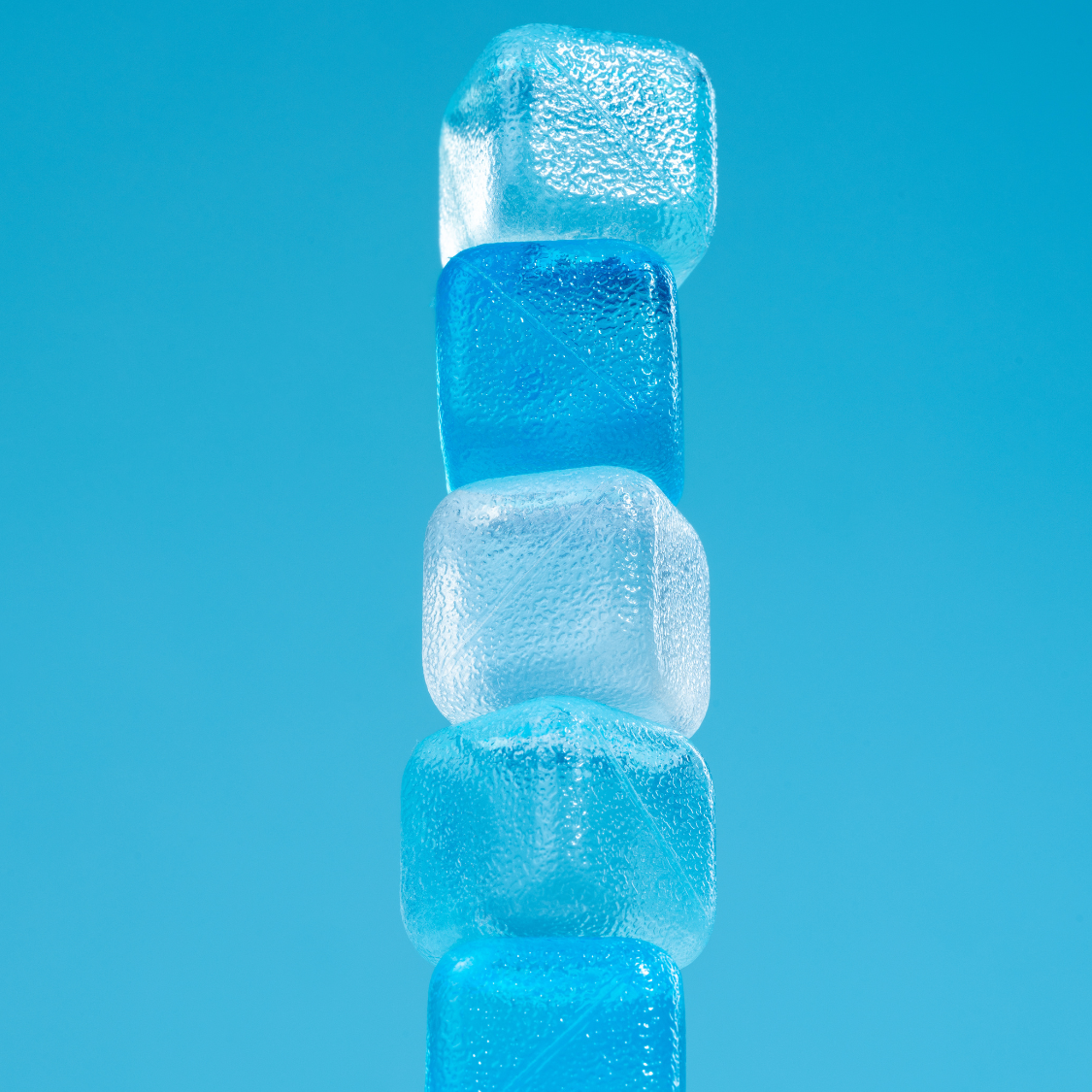 Stack of blue ice cubes against a blue background