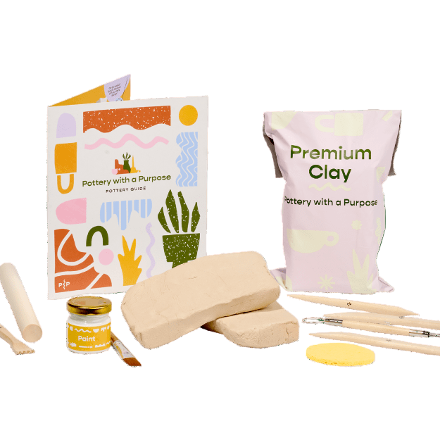Pottery-making kit with clay, tools, and instructions on a white background