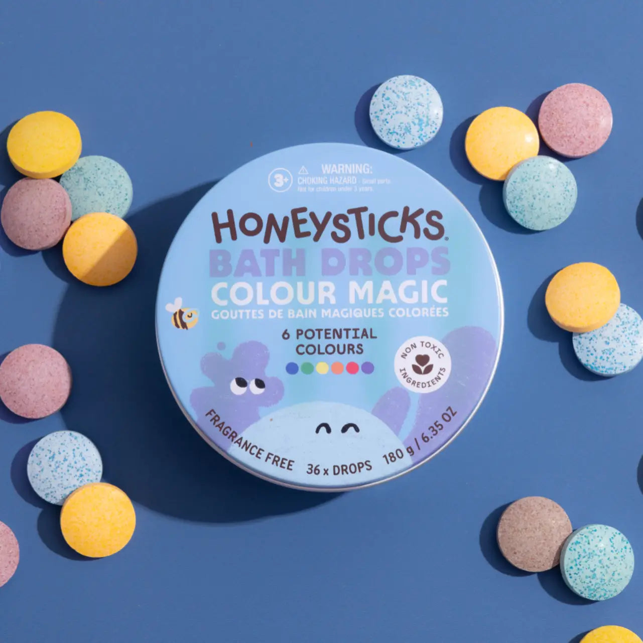 HoneySticks Bath Drops tin, with the bath drops laying on the side of the tin