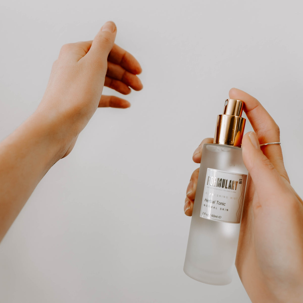 Person holding a perfume bottle labeled 'Molecule 01' against a plain background