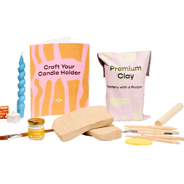 Crafting supplies including a candle, clay, and tools on a white background