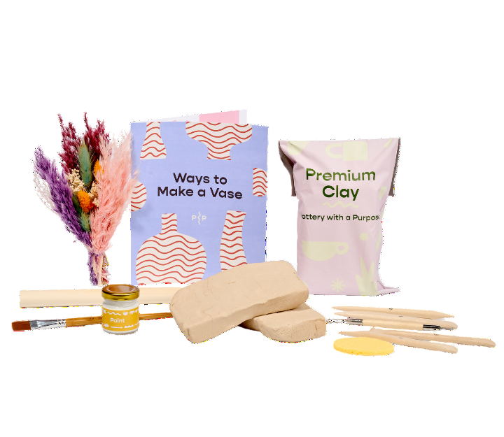 Art supplies including clay, brushes, and a book on a white background