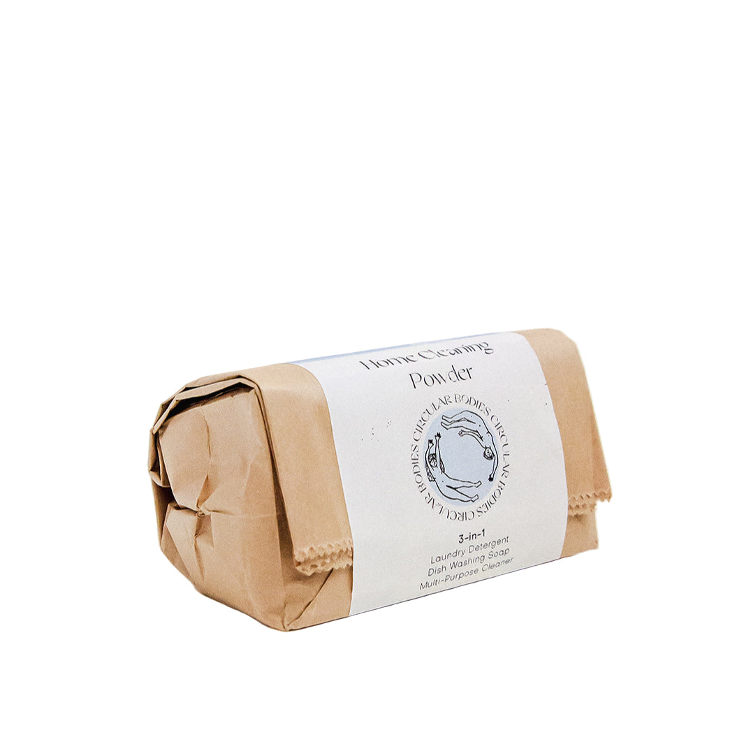 Bar of soap wrapped in brown paper with a label on a white background