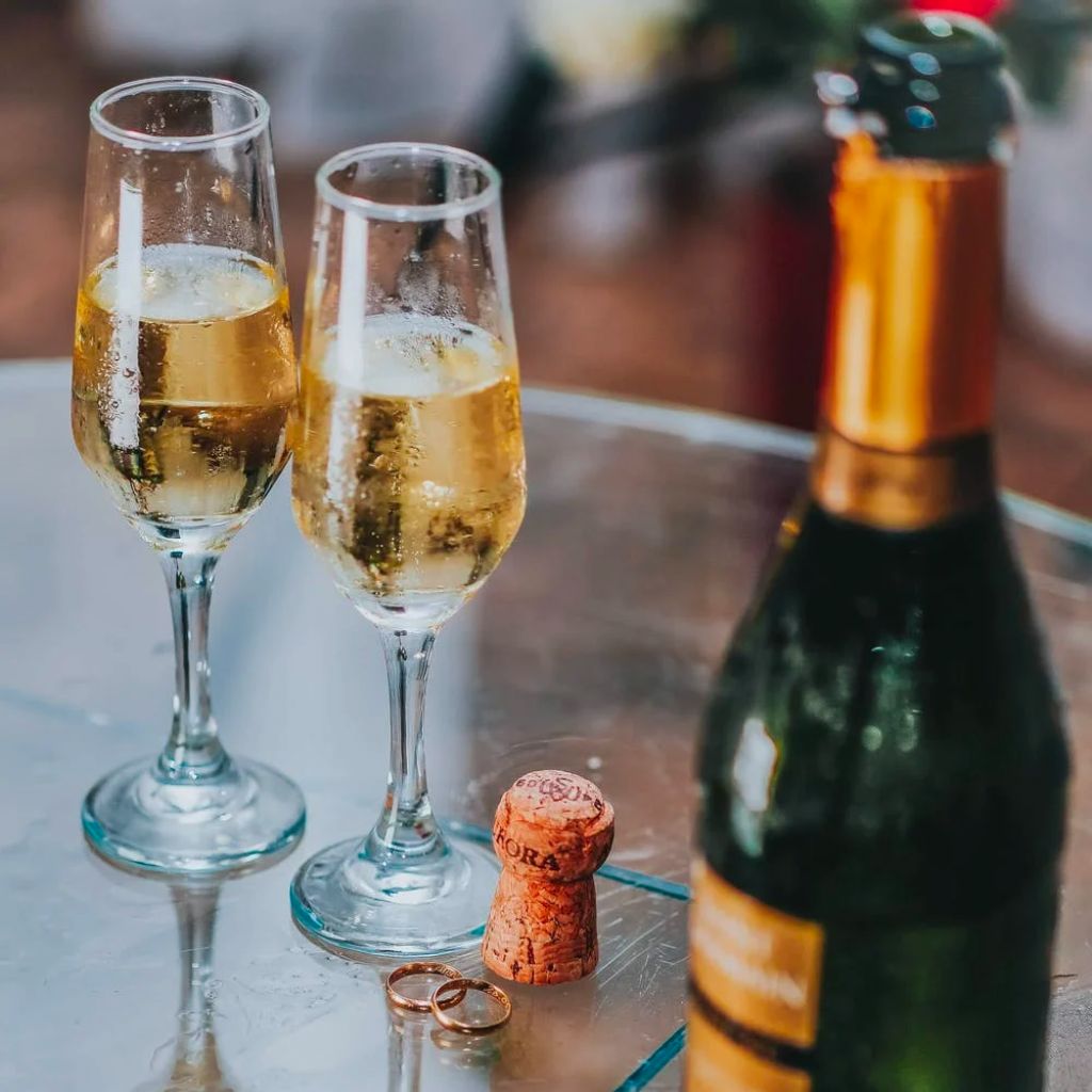 Photo of champagne bottle uncorked and two glasses