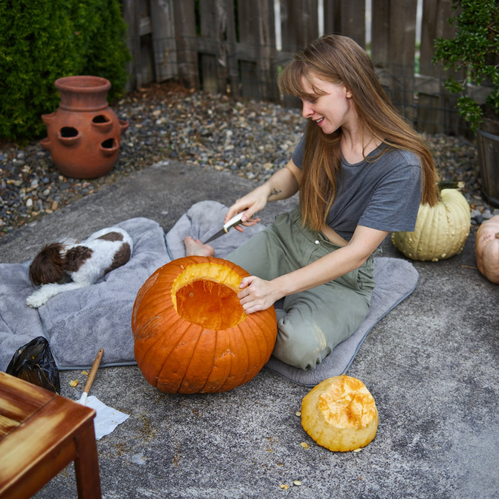 Photo of person holding a pumpkin basket surrounded by pumpkins