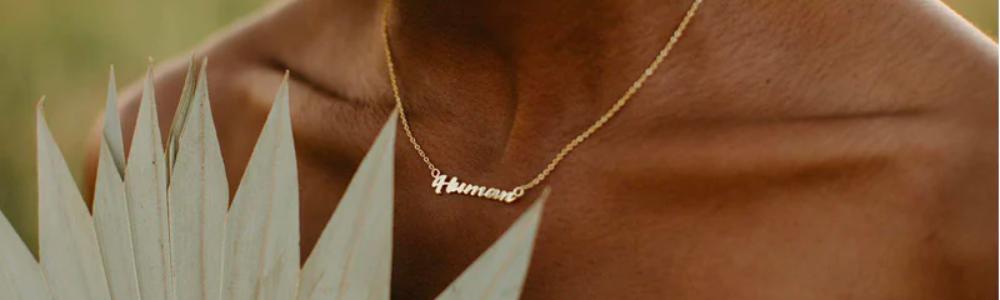 image of a human's neck and chest wearing a necklace that says "Human"