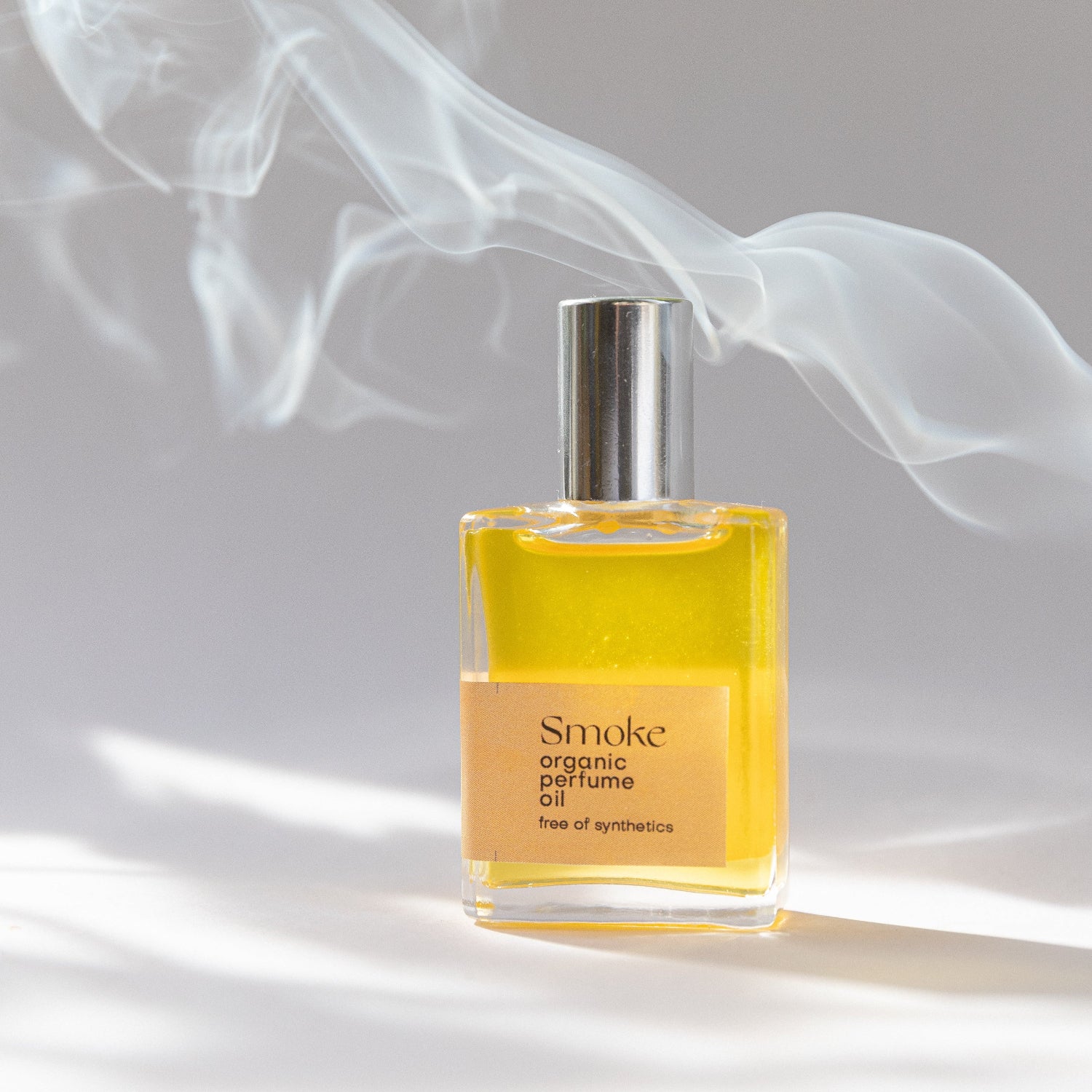 Perfume bottle labeled 'Smoke' with smoke effect on a neutral background