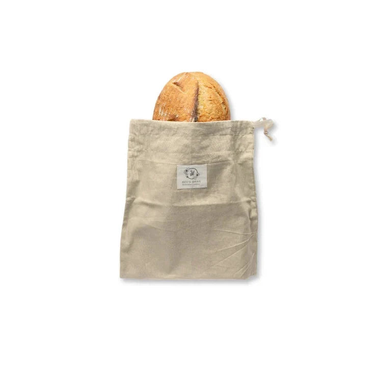 Beige reusable bread bag with a loaf of bread on a white background