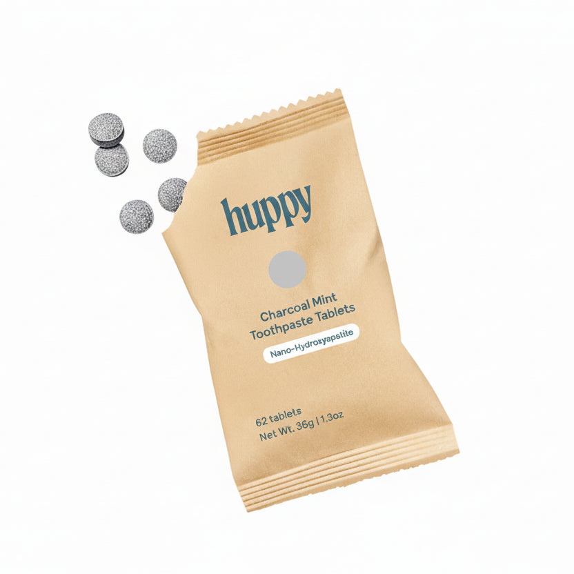 Huppy charcoal mint toothpaste tablets with packaging on a white background