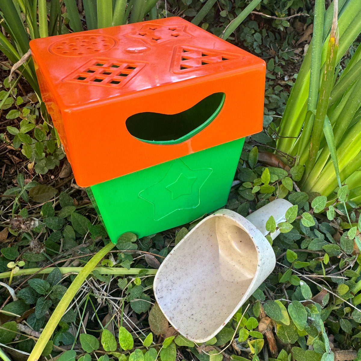 Orange and green plastic items on a grassy background