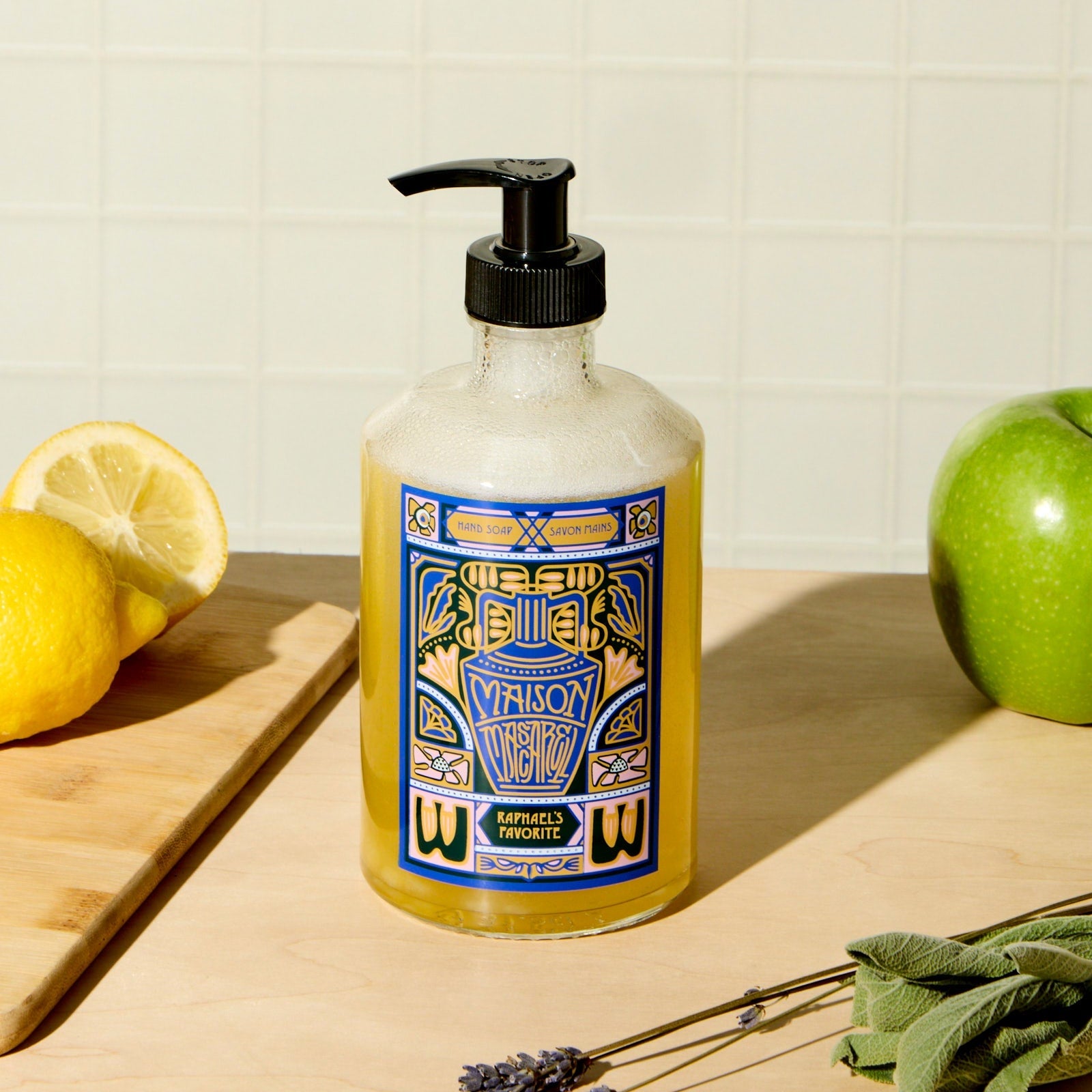 Bottle of Viallosy soap on a wooden surface with lemons, an apple, and lavender.