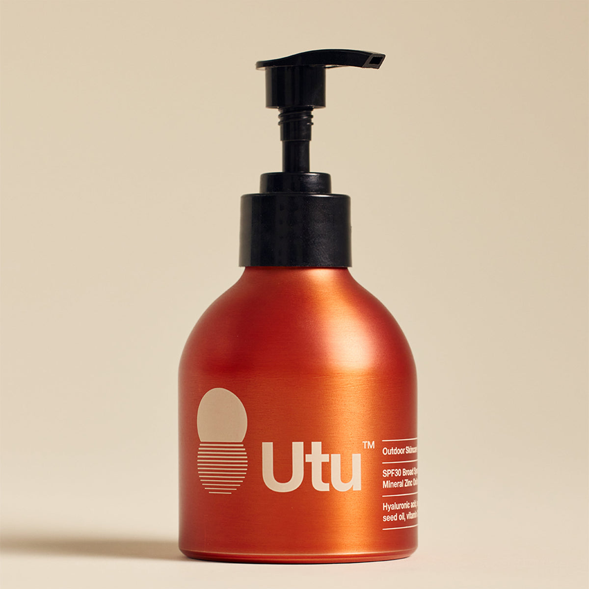 A metallic copper-orange pump bottle of Utu Outdoor Shower Gel with a black pump dispenser, set against a solid beige background.
