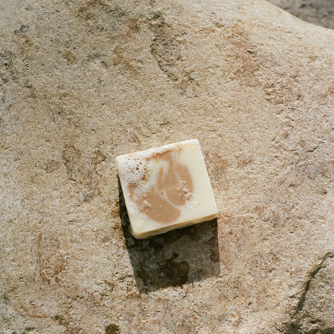 Bar of soap on a rock with water in the background