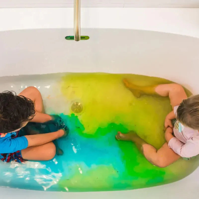 Two children in a bathtub with green water.